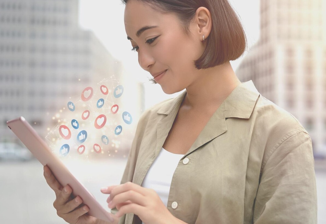 Asian woman interacting with a tablet receiving notifications
