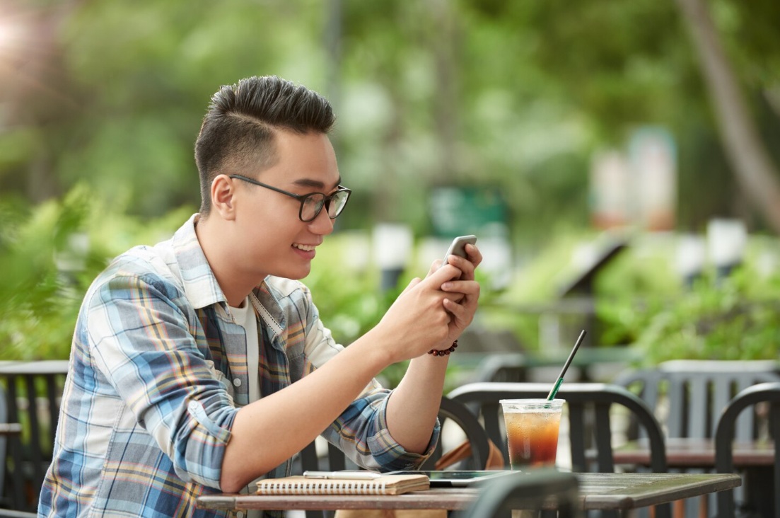 Young Vietnamese browsing Zalo on his smartphone