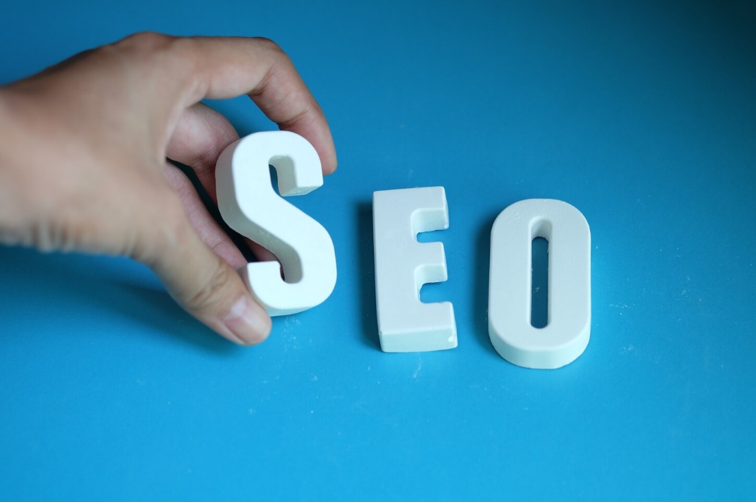 Hand arranging SEO white letters