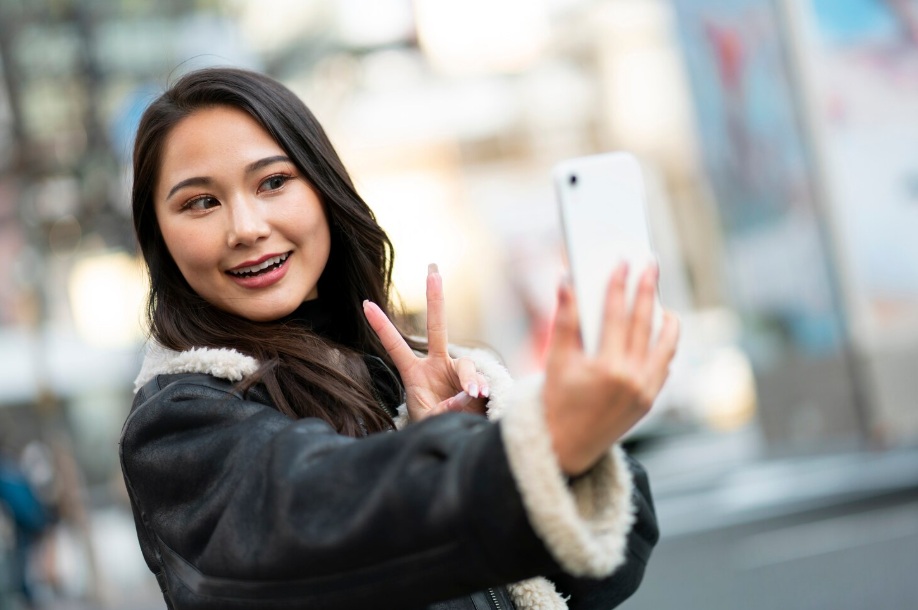 Asian woman taking a selfie on the street