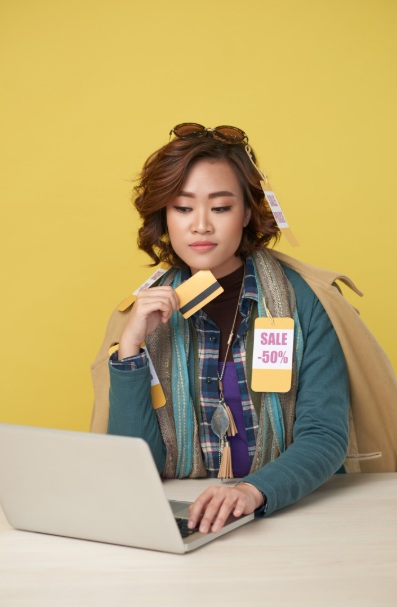 Young Asian woman purchasing discounted items on her laptop