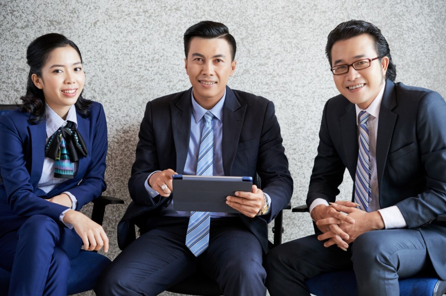 How to Outsource SEO Services: Complete Guide to Get Started 4 Three sitting business people working on a tablet